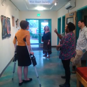 Heather Leigh, Brittnee Page, Marc Paley, and guest examine the gallery exhibition.